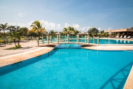 Una piscina al aire libre, sombrillas. Eurobuilding Hotel Plaza Guayana