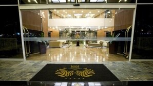 A hotel lobby with a central reception desk, seating area, and a decorative emblem on the floor. - Eurobuilding Hotel Plaza Guayana (Ciudad Guayana)