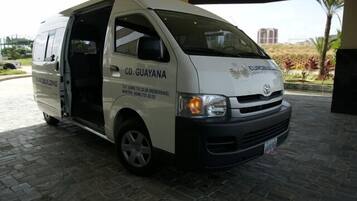 A white van with "CD. GUAYANA" and "EUROBUILDING" on the side, parked on a paved area with a building in the background.