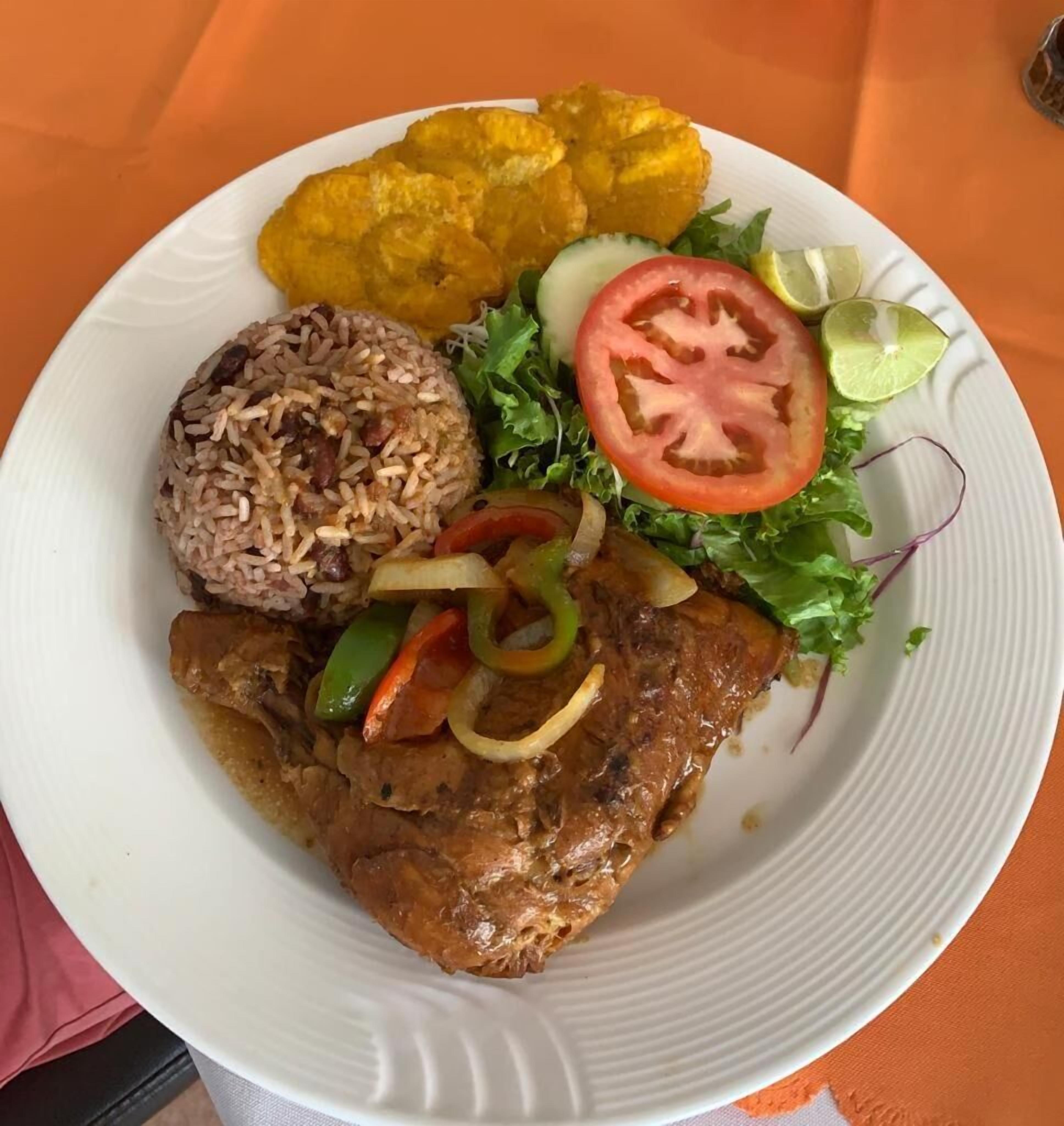 Un piatto con riso, carne, verdure e platani fritti.