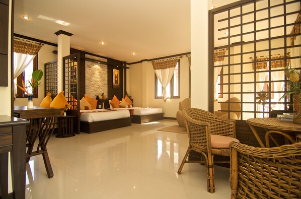 A spacious living area with a sofa set, a dining table, and wicker chairs. - Ban's Diving Resort (Koh Tao)