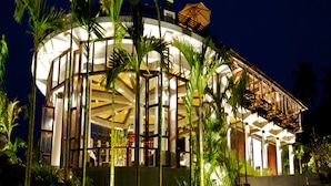 Un bâtiment moderne de forme circulaire, doté d’une façade en verre et d’un espace balcon.