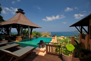 A poolside area with lounge chairs, a gazebo, and a view of the ocean. - Ban's Diving Resort (Koh Tao)