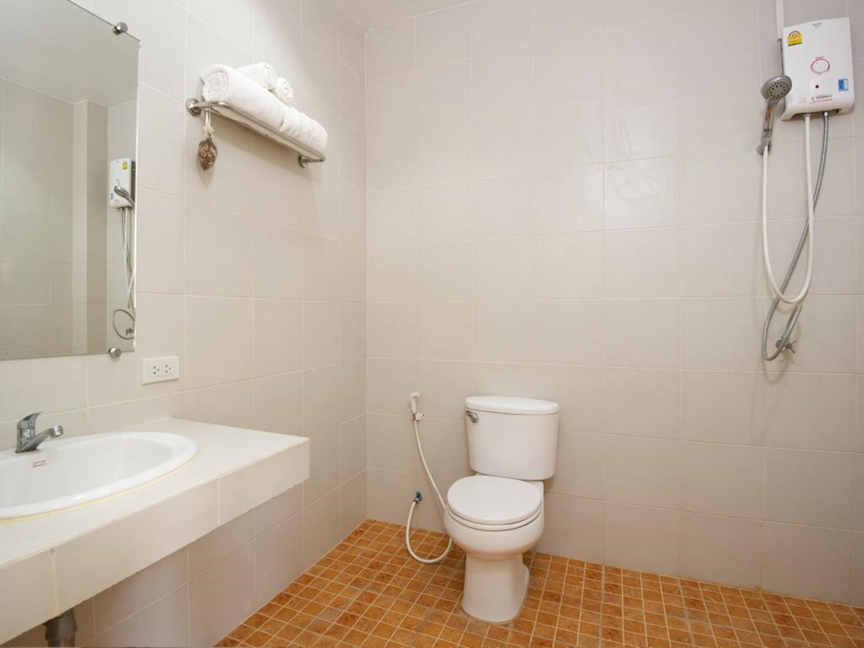 Un baño con lavamanos, inodoro y ducha.