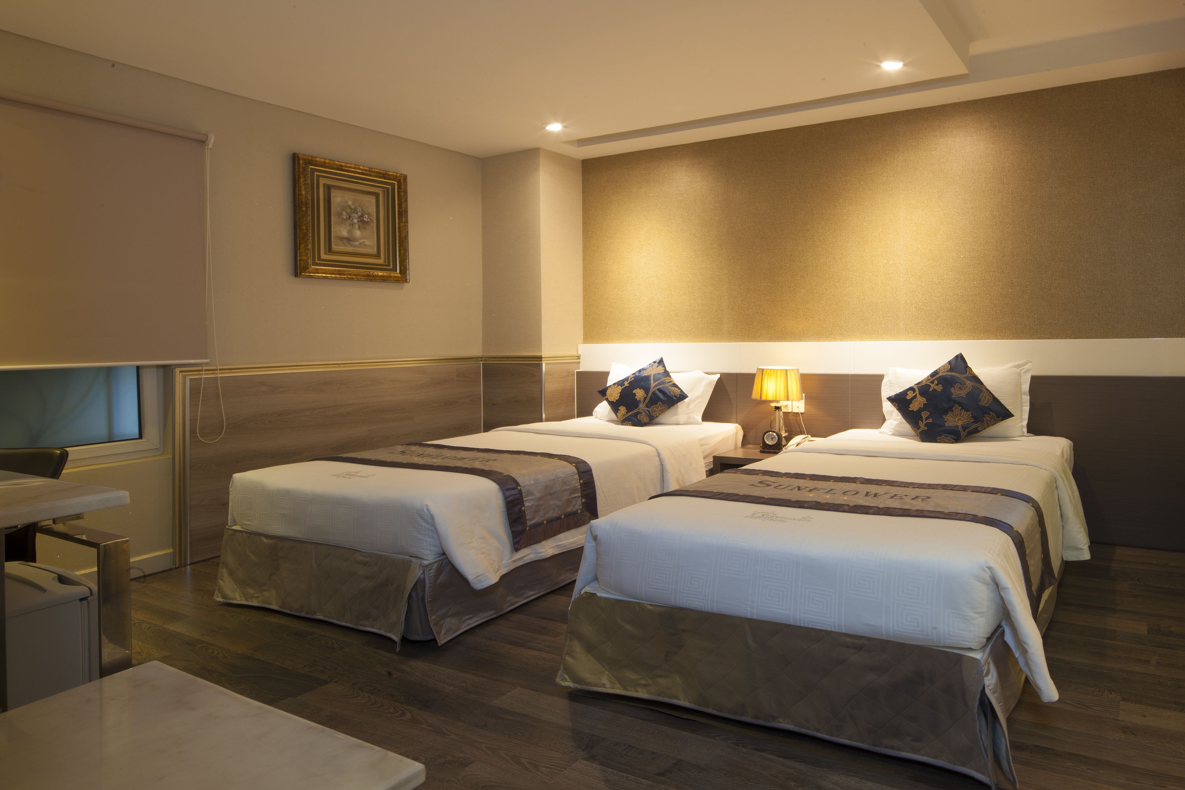 A hotel room with two beds, a desk, and a chair.