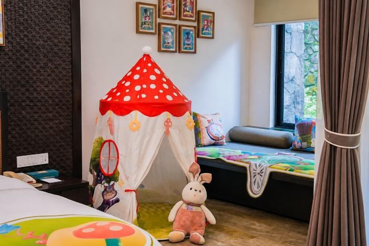 A child's room with a bed, a small tent, a plush toy, and a window with a view.