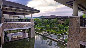 A multi-level outdoor area with a stone wall, a pool, and a dining setup. - NARADA Resort & Spa Liangzhu (Hangzhou)