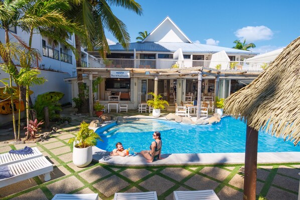 A pool area with lounge chairs, a bar, and a restaurant named 'Aquarius'. - Aquarius on the Beach (Nadi)
