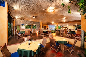 Restaurante com teto de madeira e mesas montadas para refeições.