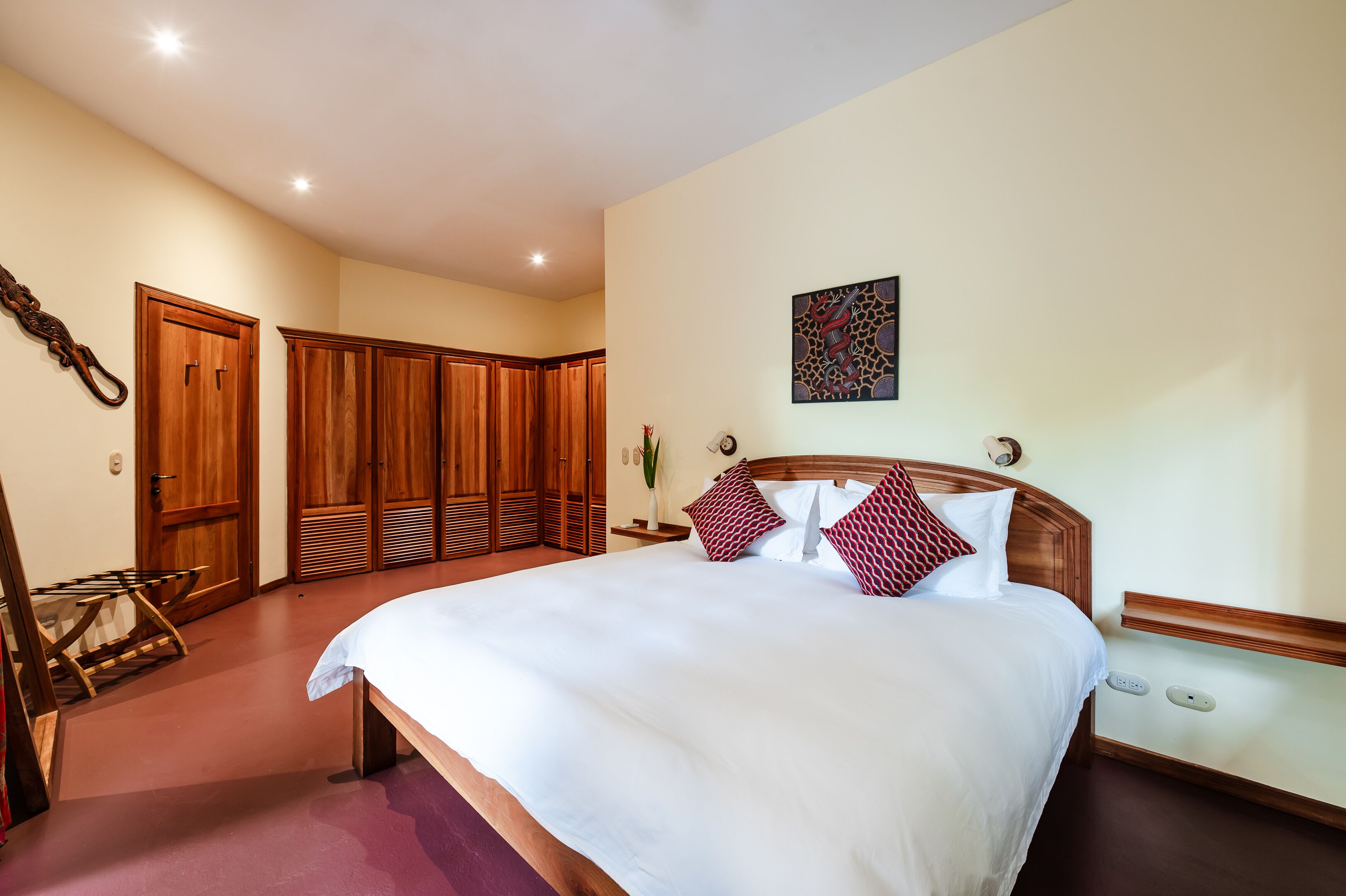 Un dormitorio con una cama grande, un armario de madera y una obra de arte colgada en la pared.