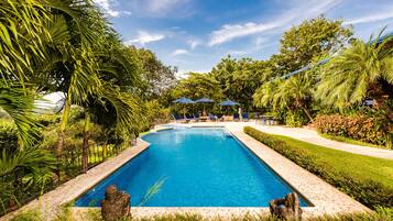 Una piscina al aire libre, sombrillas