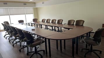 Una sala de conferencias con una larga mesa y varias sillas.