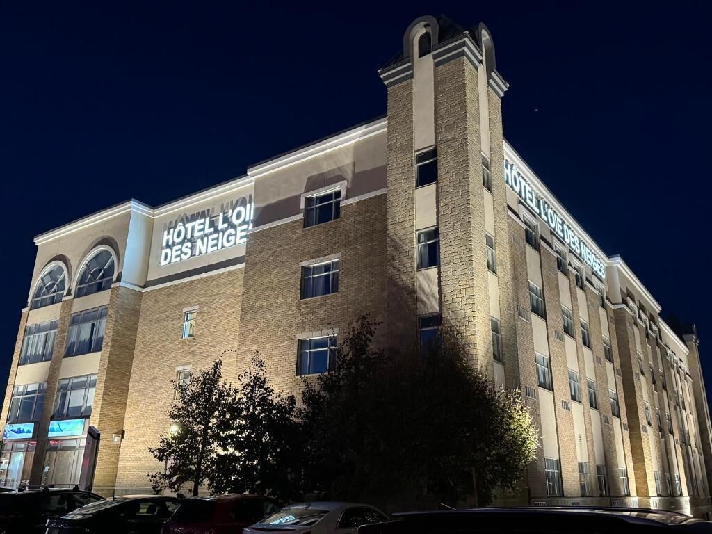 A multi-story hotel building with a prominent sign reading 'HOTEL L'ORÉAL DES NEIGE.'