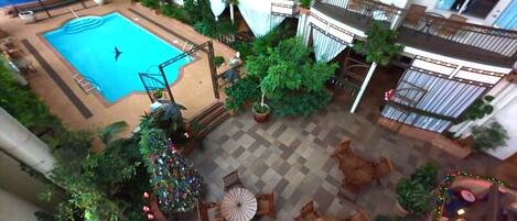 Zona de piscina interior con vista al interior del edificio, que incluye balcones y zonas de estar.