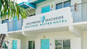 A hotel with a sign reading "Hollywood Beachside Boutique Suites Hotel".
