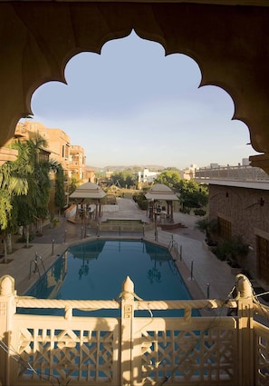A pool area with a view of a traditional building and a clear sky.