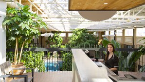 A restaurant with a wooden ceiling, a bar area, and a large potted plant. - Hotel L'Oiseliere Montmagny (Montmagny)