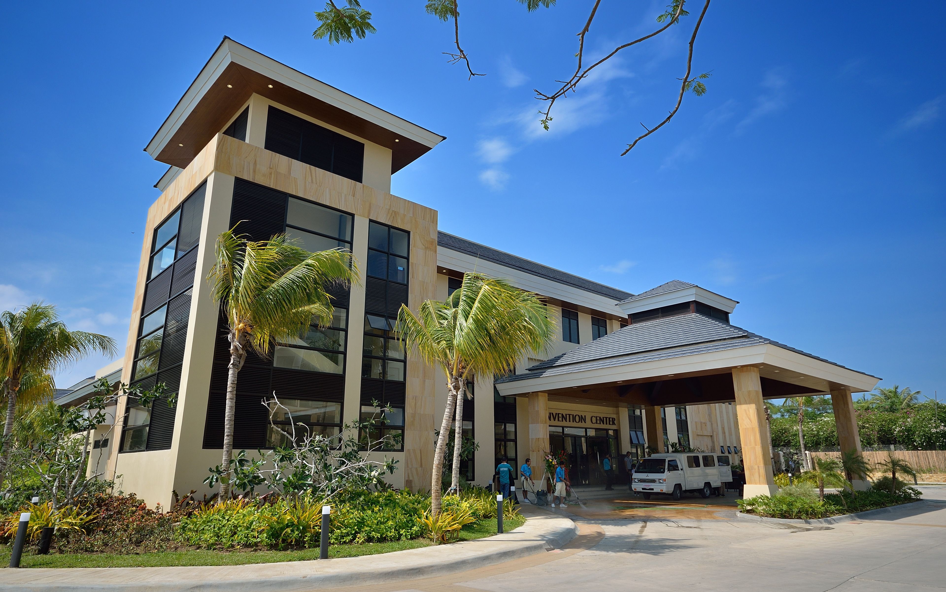 A modern building with a flat roof, large windows, and a covered entrance area.