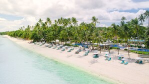 A beach resort with a long stretch of white sand, palm trees, and a clear blue sea. - Henann Resort Alona Beach (Panglao)