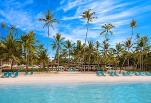 On the beach, white sand, sun loungers, beach umbrellas