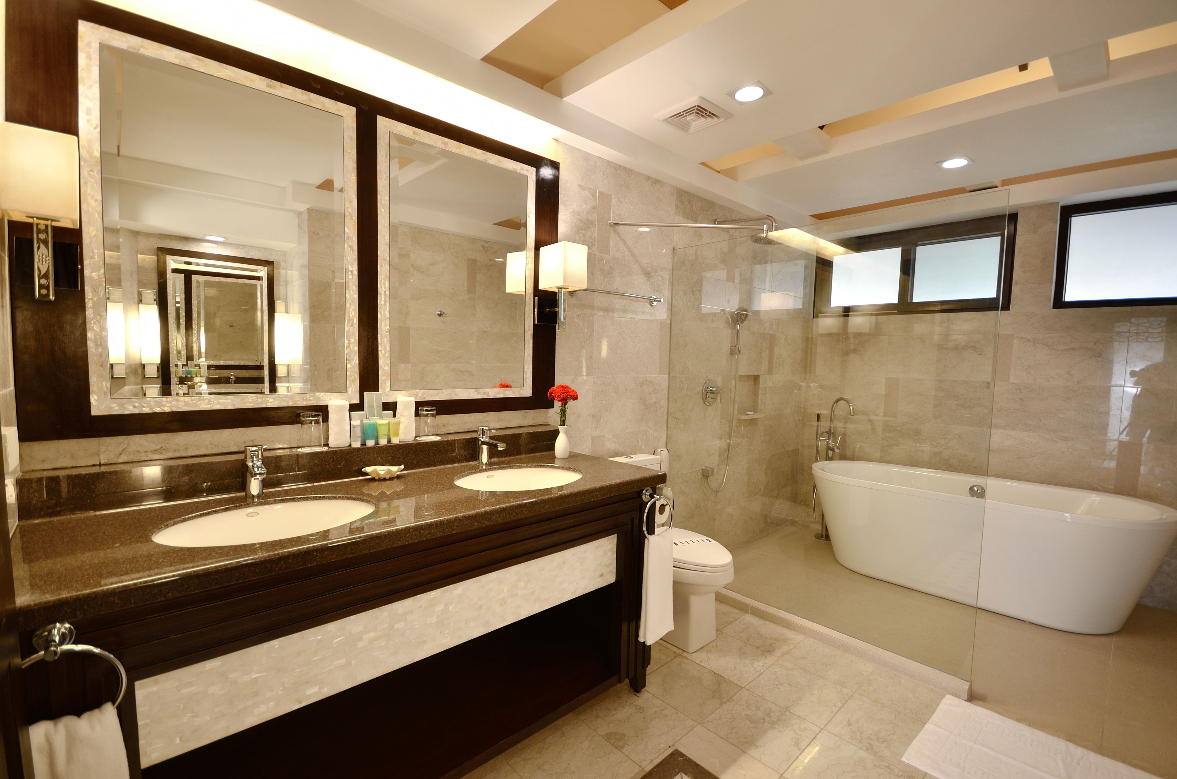 A modern bathroom with two sinks, a large mirror, a shower, and a bathtub.