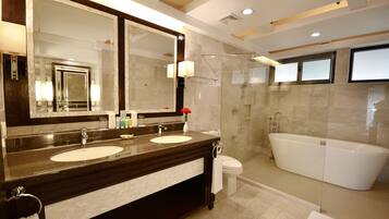 A modern bathroom with two sinks, a large mirror, a shower, and a bathtub.