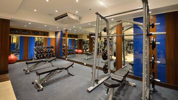 Une salle de sport équipée de matériel de musculation, de ballons d’exercice et d’haltères.