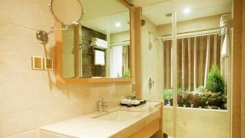 A bathroom with a sink, mirror, and shower.