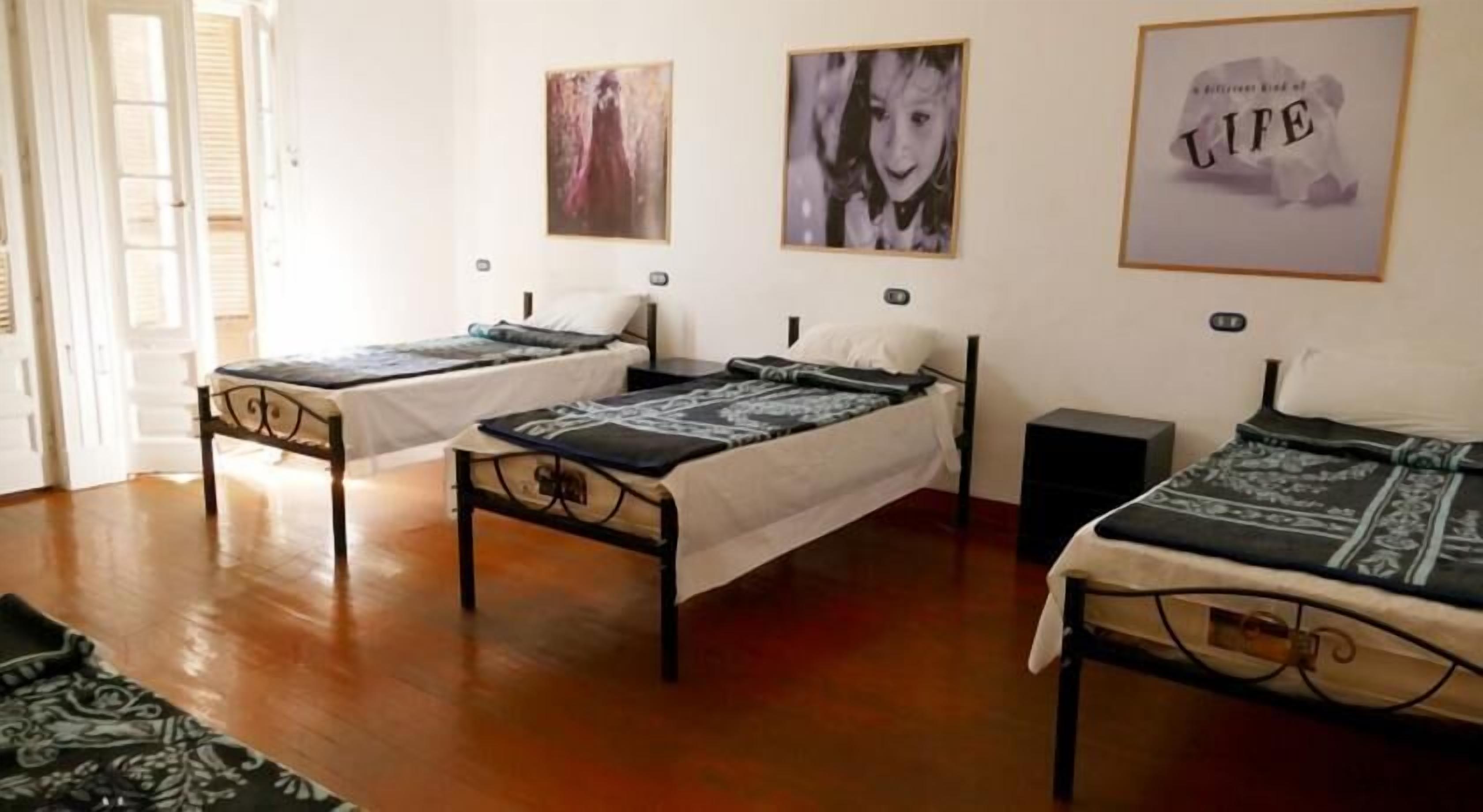 A room with two single beds, a small table, and a speaker.