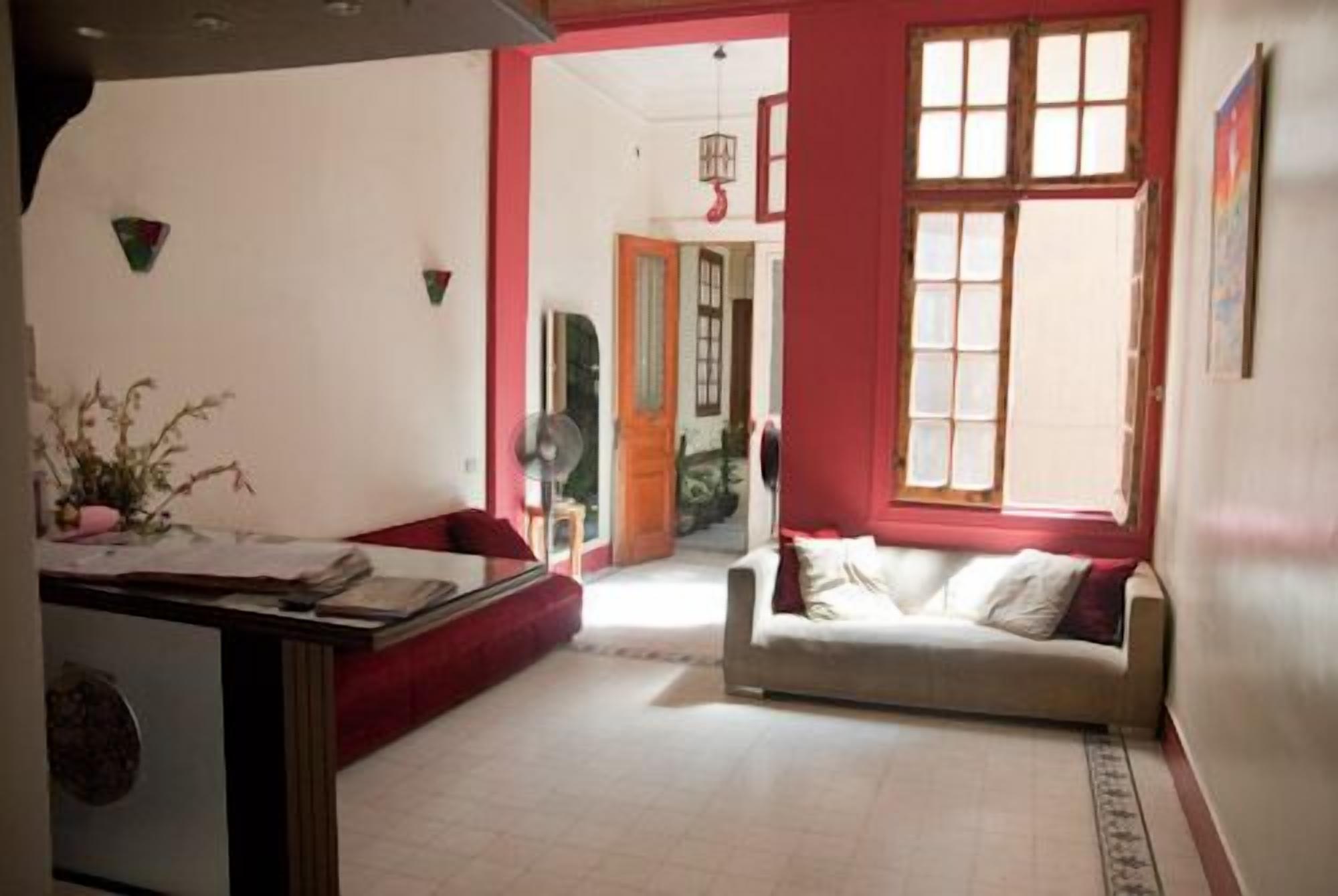A room with a sofa, a desk, and a window with multiple panes.