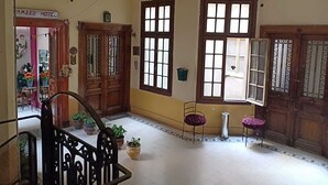 A hotel lobby with wooden doors, large windows, and potted plants. - Meramees Hostel (Cairo)