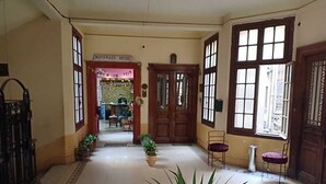 A hotel lobby with a tiled floor, wooden doors, and potted plants. - Meramees Hostel (Cairo)