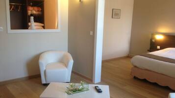 Une chambre d’hôtel avec un lit, une chaise, une petite table avec une télécommande et un miroir qui reflète un placard rempli de vêtements.