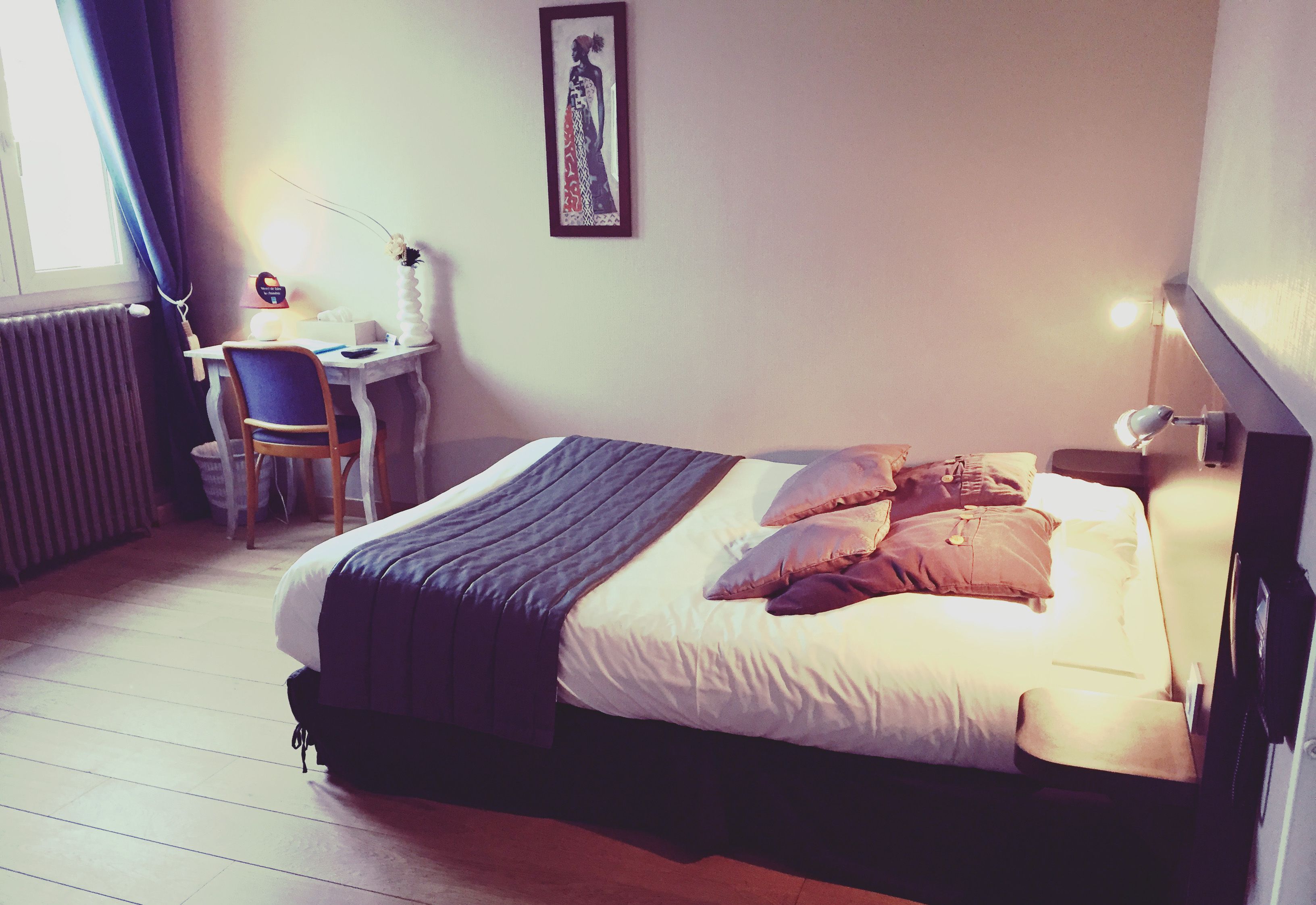 A bedroom with a bed, a desk, and a chair.