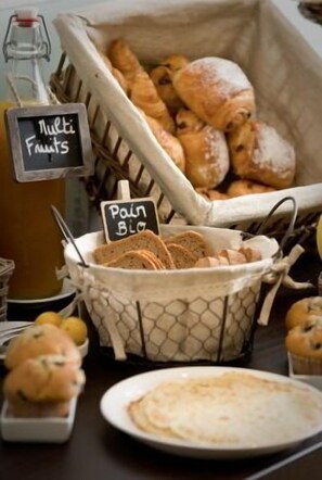A breakfast buffet with a variety of breads, pastries, and fruits. - Hotel Haut Koenigsbourg - Table d'Hotes (Thannenkirch)
