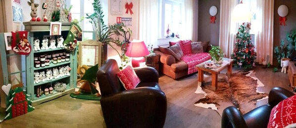 Una sala de estar acogedora con un sofá de cuero, una mesa de centro y una estantería llena de libros y objetos decorativos.