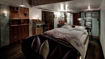 Un dormitorio moderno con una cama grande, estanterías de madera, un tocador y un vestidor.