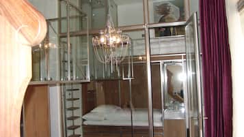 A modern room with a bunk bed, a chandelier, and a glass partition.