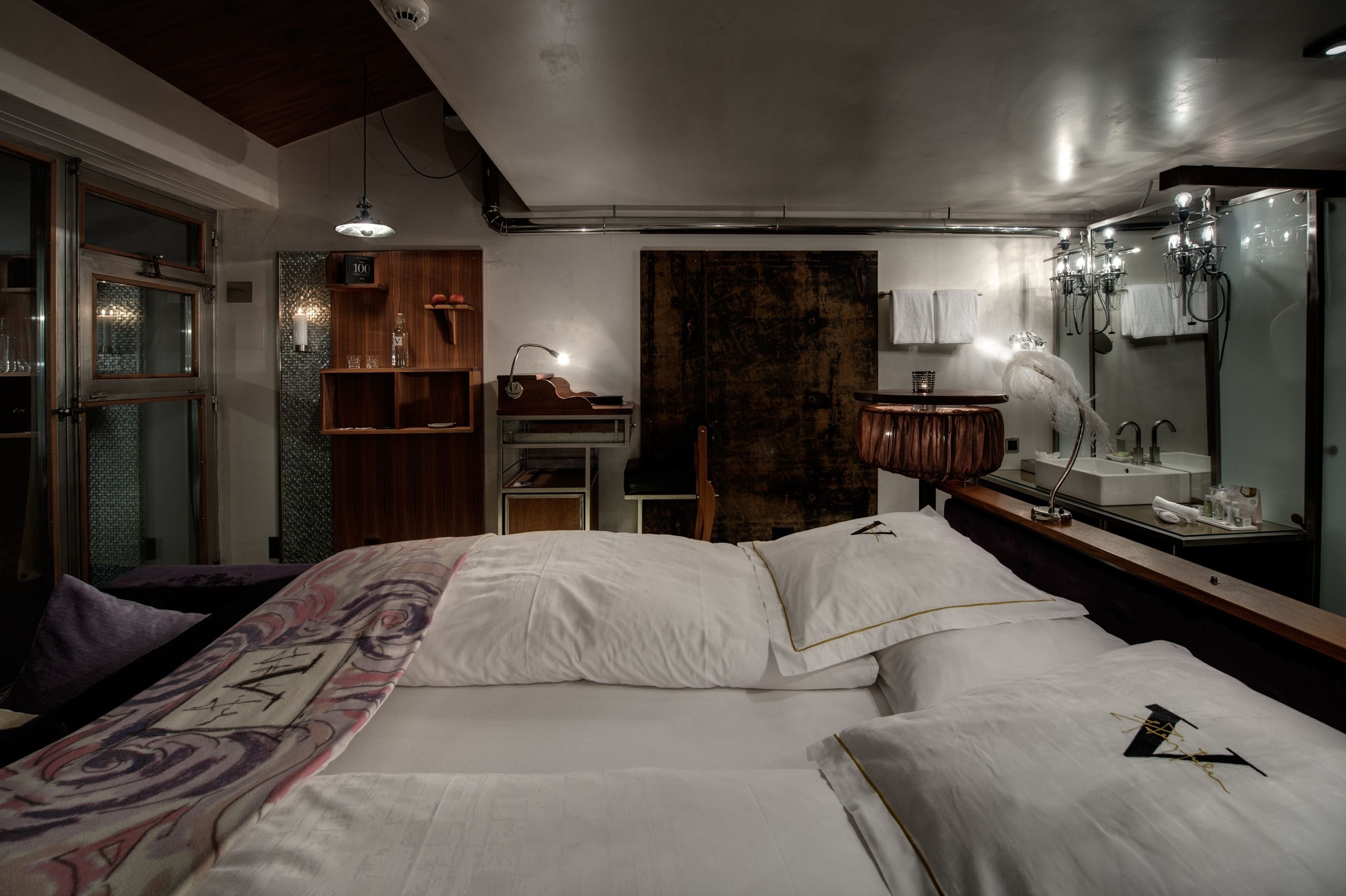 Una camera d'albergo con un letto grande, un comò in legno, una toeletta con specchio e un'ampia finestra.