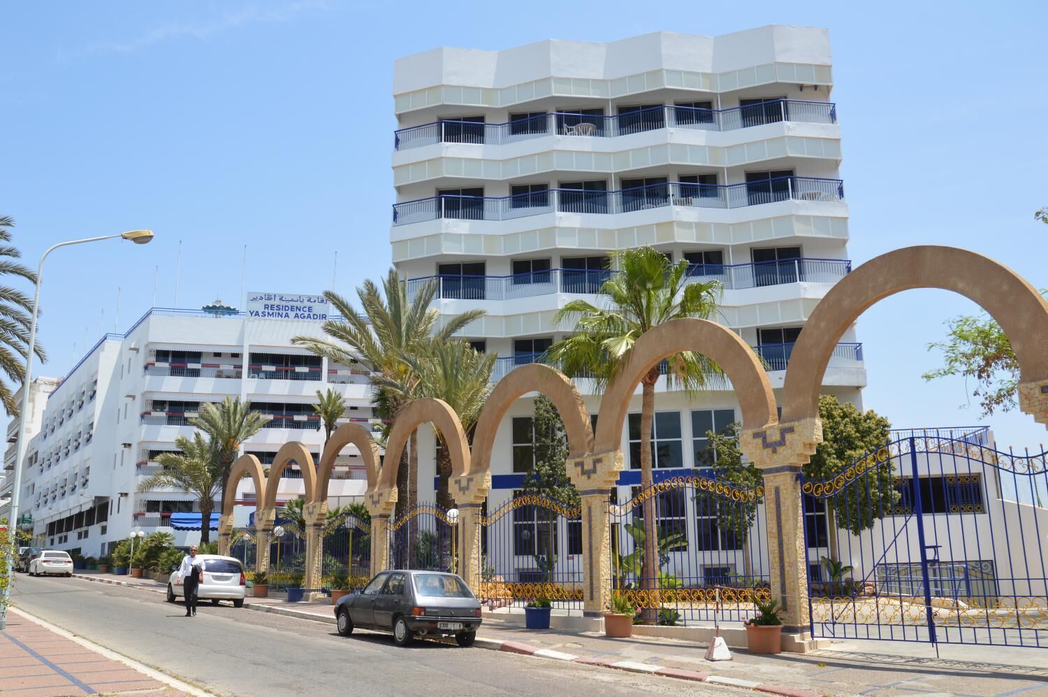 A multi-story building with a modern design, featuring a prominent entrance with arched structures.