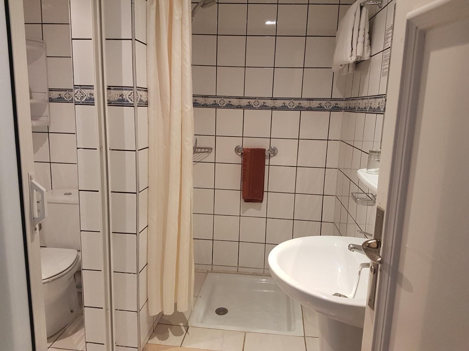 Ein Badezimmer mit Dusche, Toilette und Waschbecken.