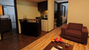 A compact living space with a kitchenette, a sofa, and a dining area. - Suite Hotel Merlot (Majzoub)