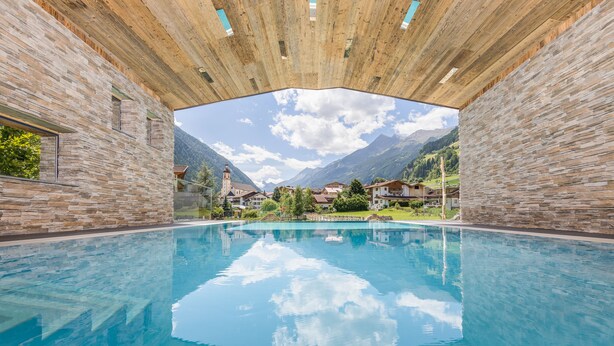 Una piscina con vista despejada a montañas e iglesia al fondo.
