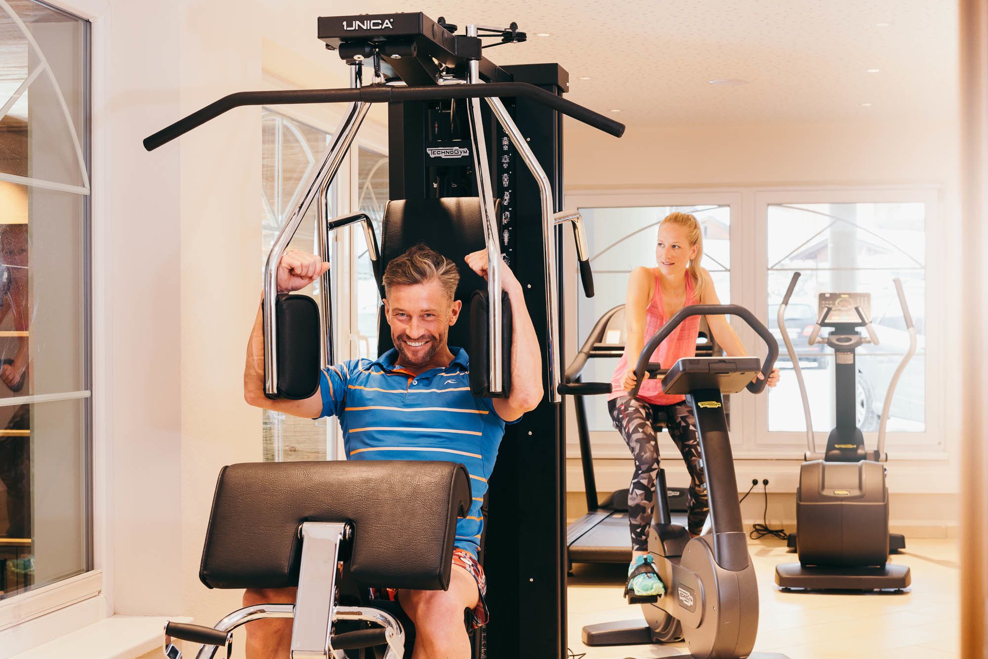 Un gimnasio con equipo de ejercicio, incluyendo una barra de dominadas y una bicicleta estática.