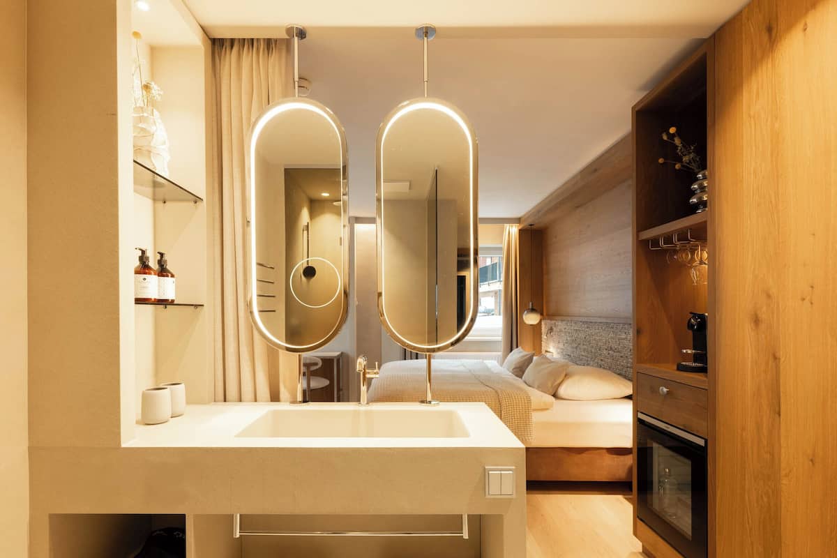 Un baño moderno con un espejo grande, un lavamanos y una ducha.