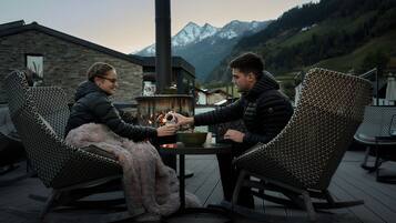 Dos personas sentadas a una mesa con vistas a montañas al fondo.