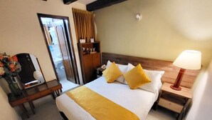 A hotel room with a bed, bedside table, lamp, and a wooden nightstand. - Hotel Ambalá Bogotá Colonial (Bogotá)