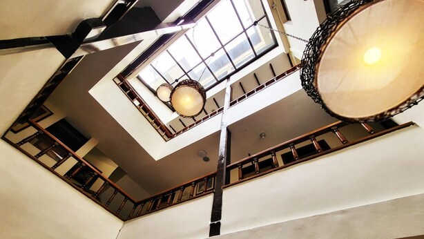 A multi-level interior with a central staircase, a hanging light fixture, and a large drum-like object. - Hotel Ambalá Bogotá Colonial (Bogotá)