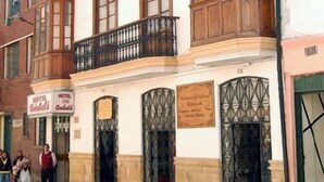 A two-story building with a balcony on the second floor. There are two doors with decorative ironwork and a sign above the doors. - Hotel Ambalá Bogotá Colonial (Bogotá)