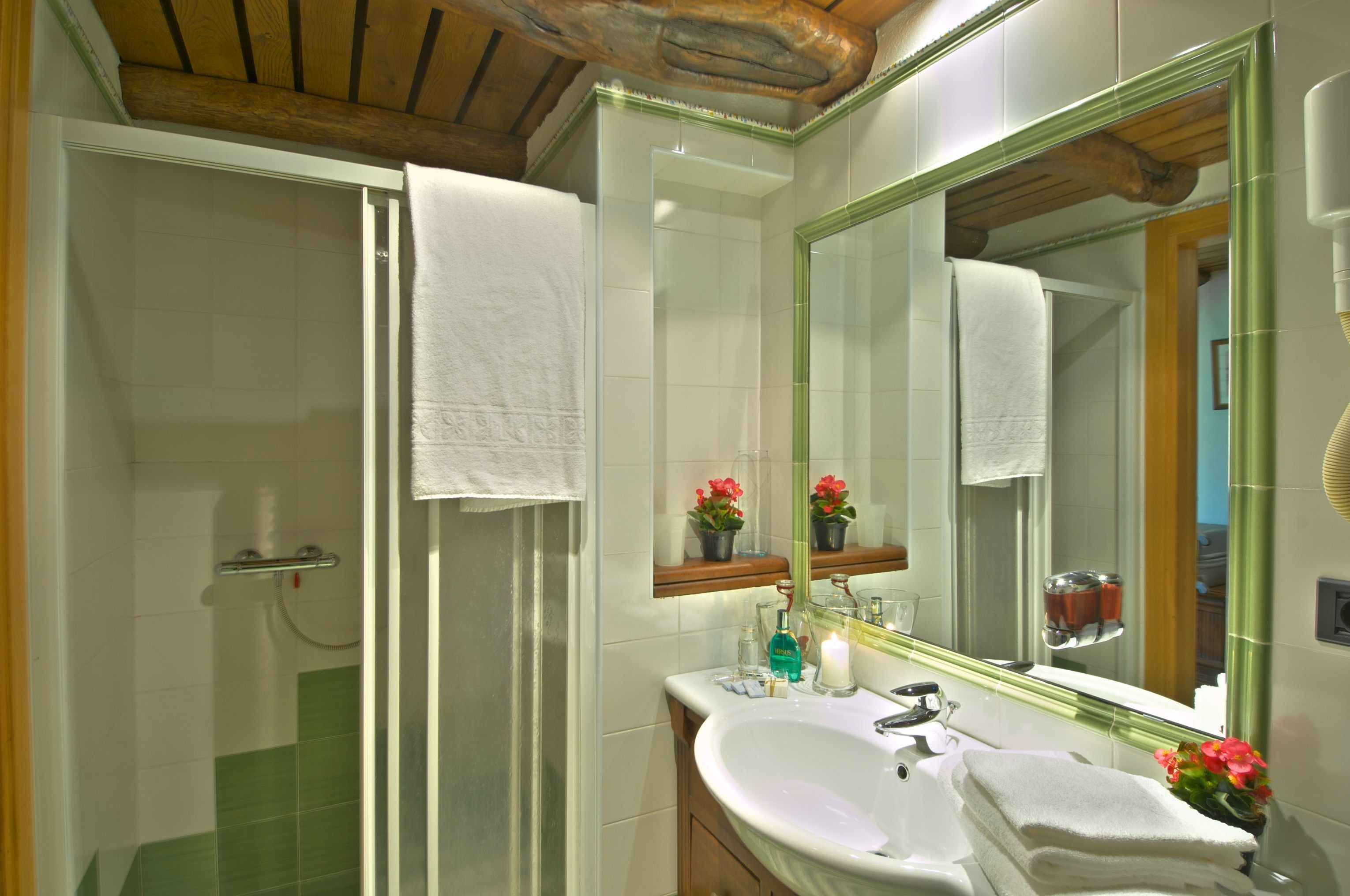 Une salle de bain avec une douche, un lavabo et un miroir.